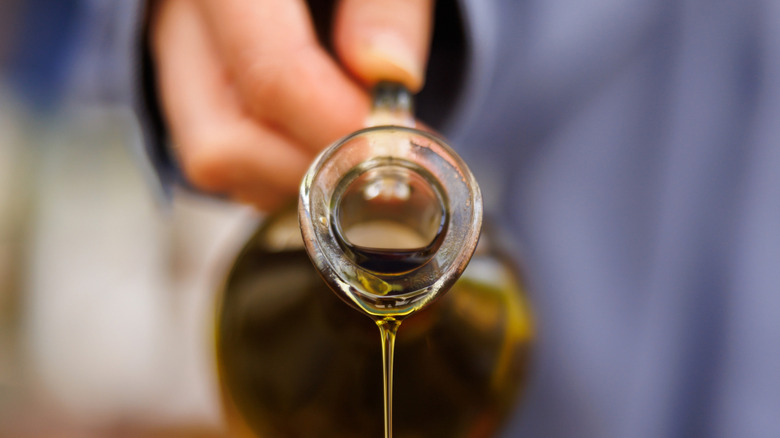Hand drizzling extra virgin olive oil