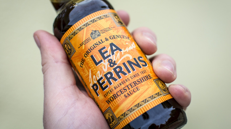 Hand holding bottle of Lea & Perrins Worcestershire  sauce