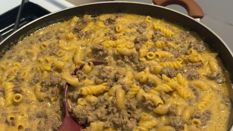 Hamburger Helper cooking with ground beef and pasta in a pot