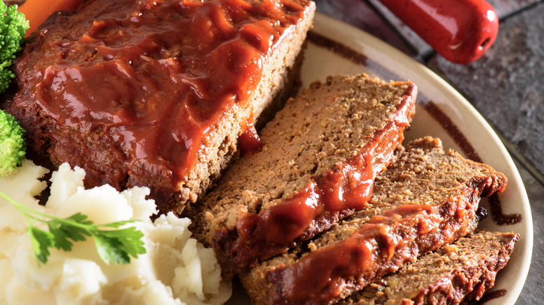 Sliced meatloaf glazed with ketchup, served with mashed potatoes