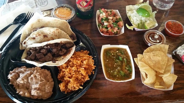A beef taco platter with an assortment of salsas and chips