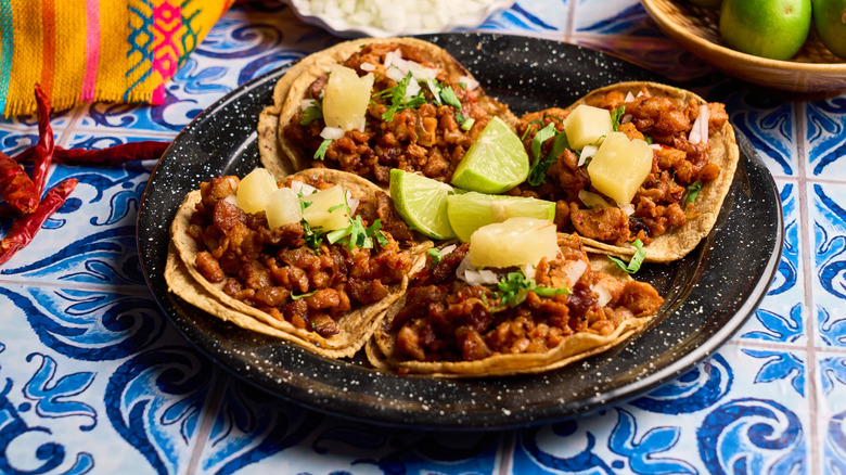 A plate of traditional al pastor tacos