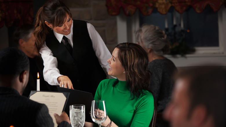 Woman with waitress at restaurant