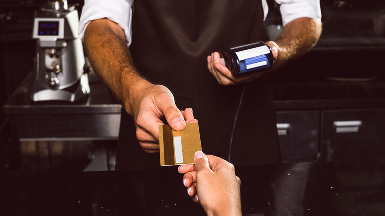 Woman paying with credit card at restaurant