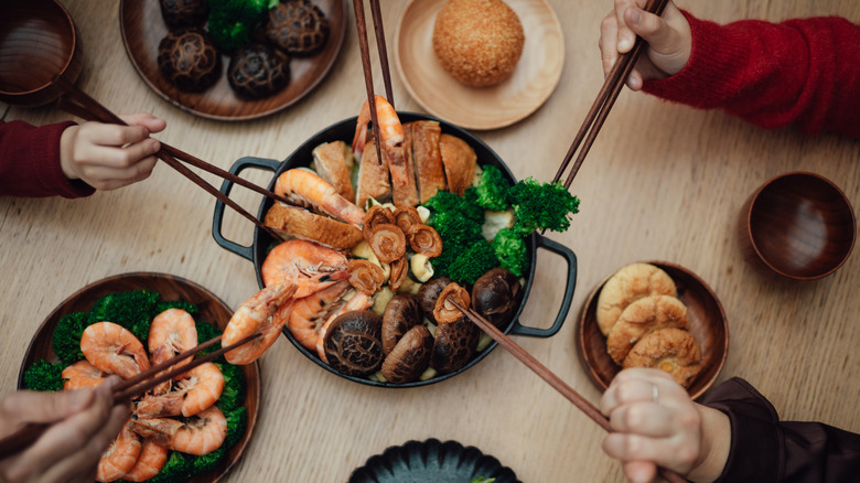 A family sharing a dish of Chinese food