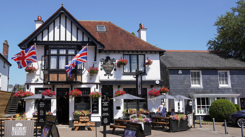 a white pub with black beams and union jack flags outside