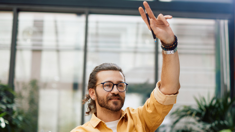main raising hand to call over waiter
