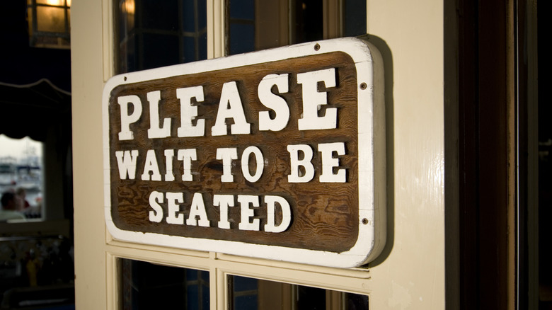 please wait to be seated sign
