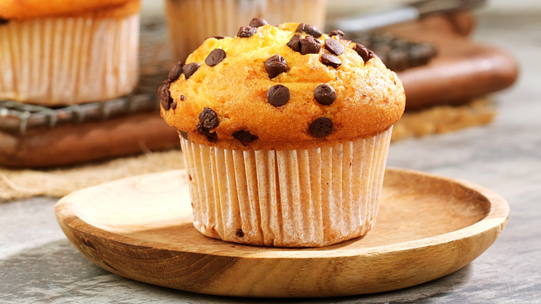Chocolate chip muffin on wooden plate