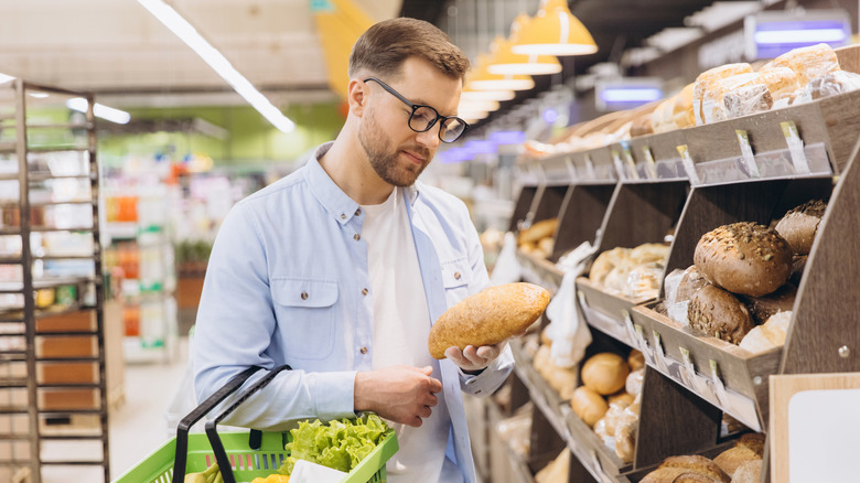 Supermarket shopper examining bread loaf