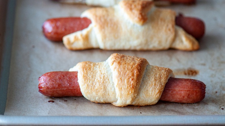 Baked hot dogs wrapped in crescent rolled