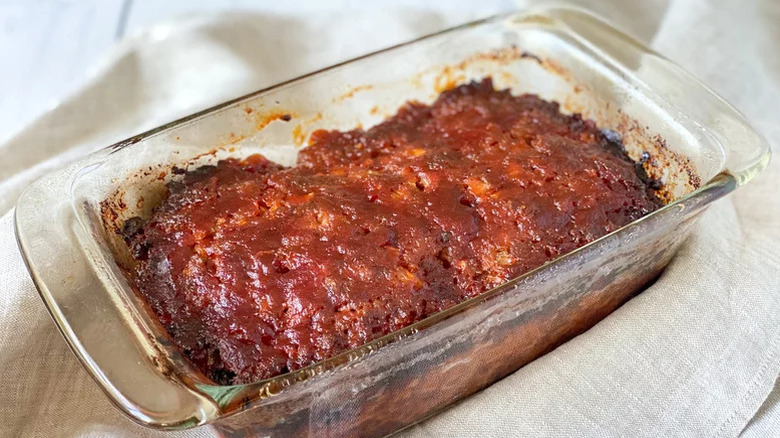 A glass baking dish of freshly cooked meatloaf