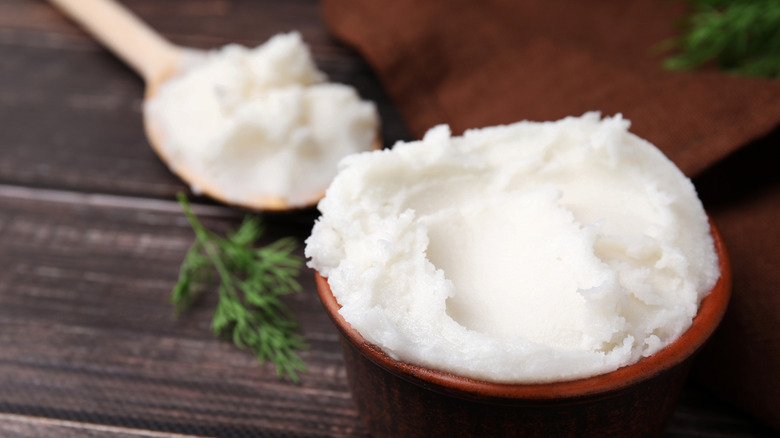 Pork lard in a bowl with a wooden spoon on the side