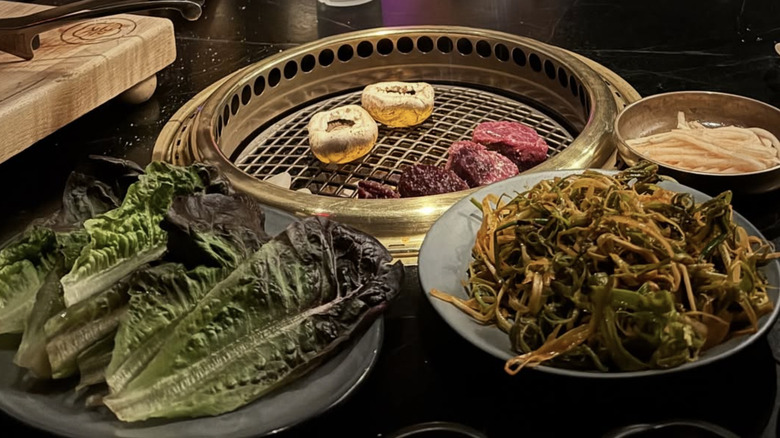 A spread of meats, lettuce, and noodles at Cote steakhouse