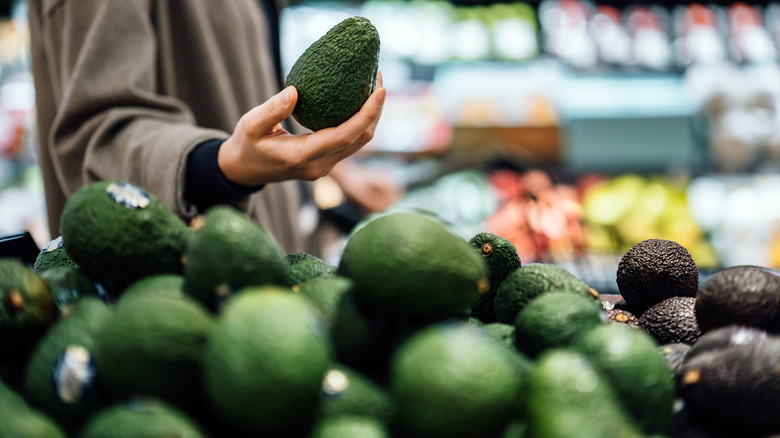 shopper picking up avocado
