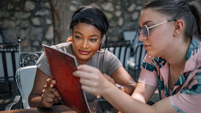 Two women reading menu at restaurant