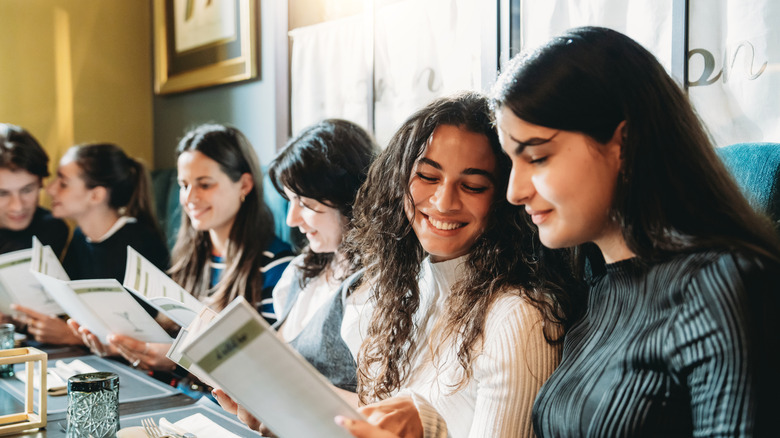 Group of friends talking while picking items off menu