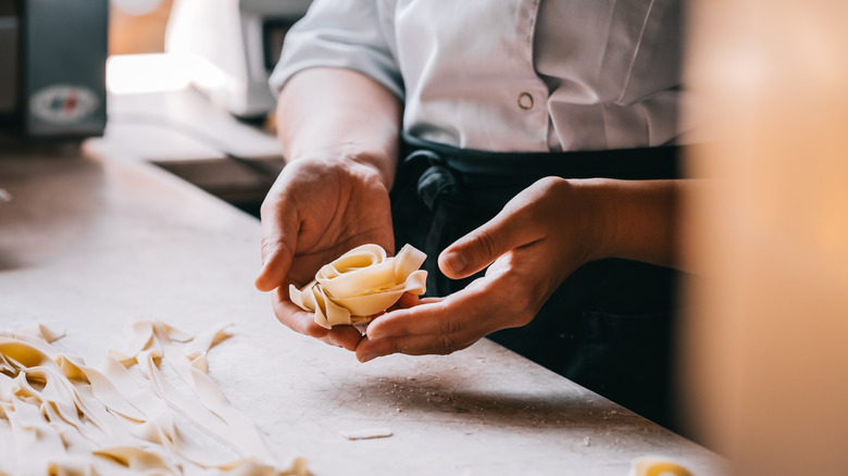 Hands holding freshly made tagliatelle