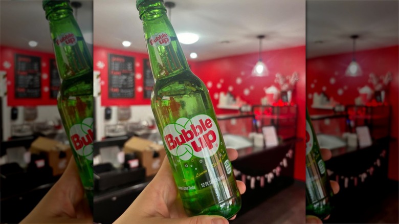 Hand holding bottle of Bubble Up soda