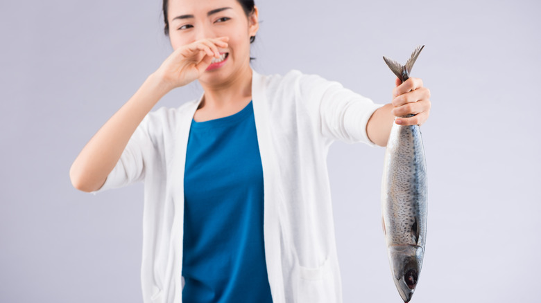 Woman reacting to foul smelling fish