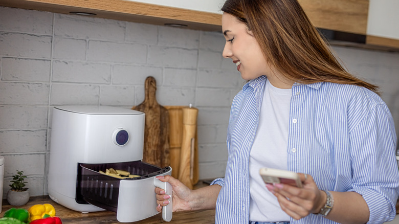 A woman using an air fryer
