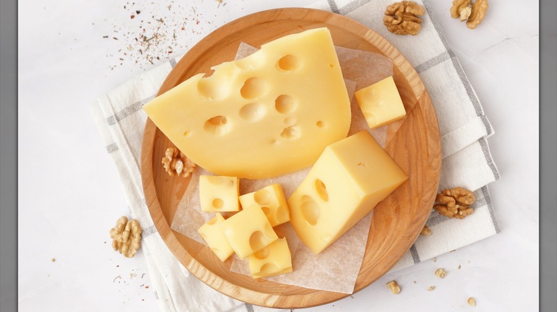 Pieces of Swiss cheese on a wooden cheese board