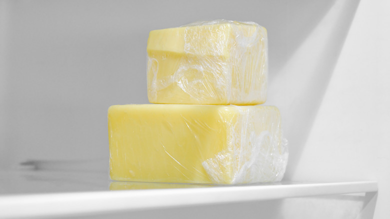 Pieces of cheese wrapped in plastic in fridge