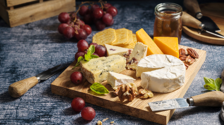 Various cheeses on a wooden cheese board