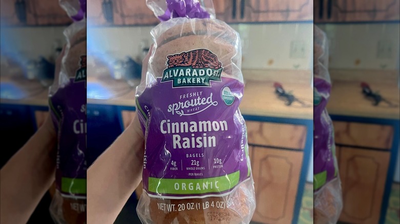 Hand holding package of Alvarado Street Bakery Cinnamon Raisin Bagels