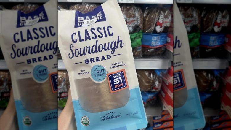 Hand holding pack of Base Culture Classic Sourdough Bread