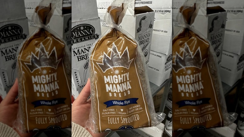 Hand holding loaf of Mighty Manna Whole Rye Sprouted Bread