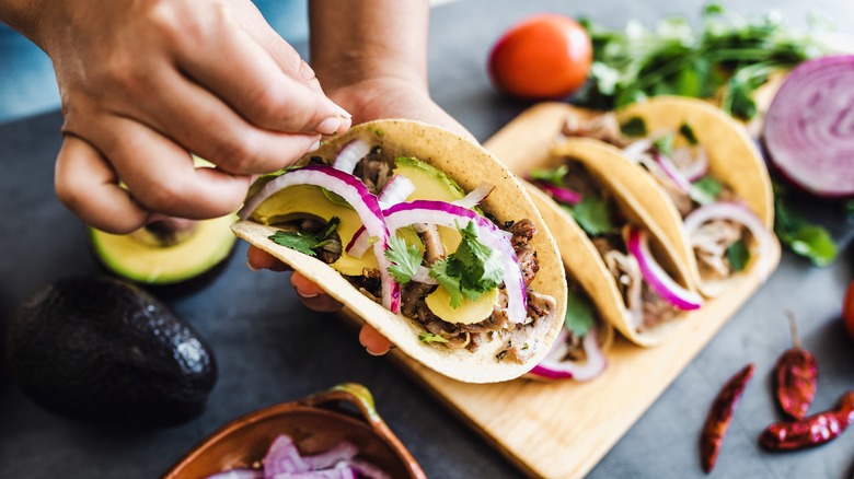 hands preparing tacos