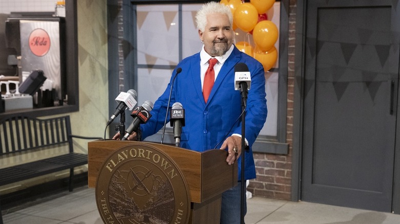 Guy Fieri at the podium of Flavortown about to open the gates