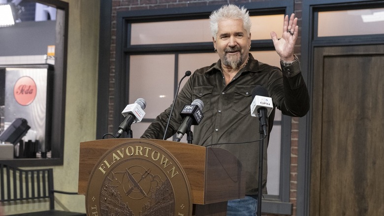 Guy Fieri at podium on "Flavortown Food Fight" set