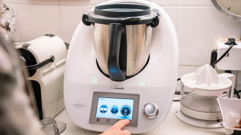 Person touching Thermomix in kitchen 