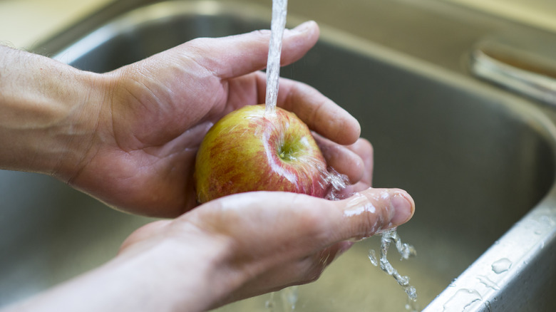 Hands washing apple