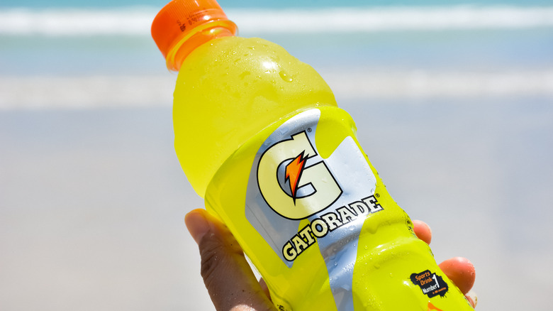   trzyma żółtą butelkę gatorade