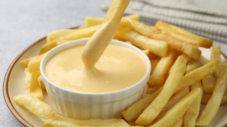 Fry dipping into bowl of flavored mayo