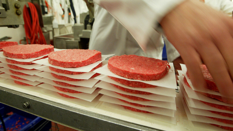 Person arranging stacks of hamburger patties for wholesale