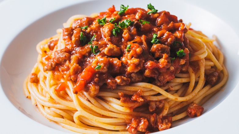 Bolognese sauce over spaghetti on plate