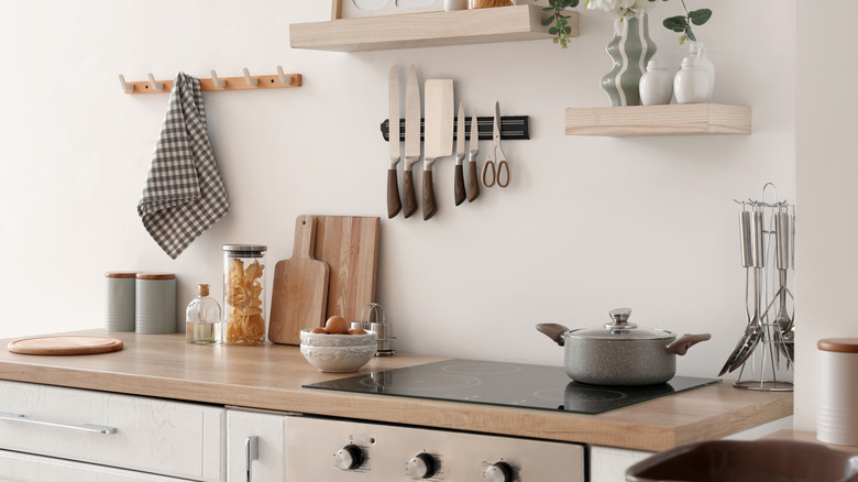 A cozy kitchen with various utensils and other types of kitchenware sitting on the counter.