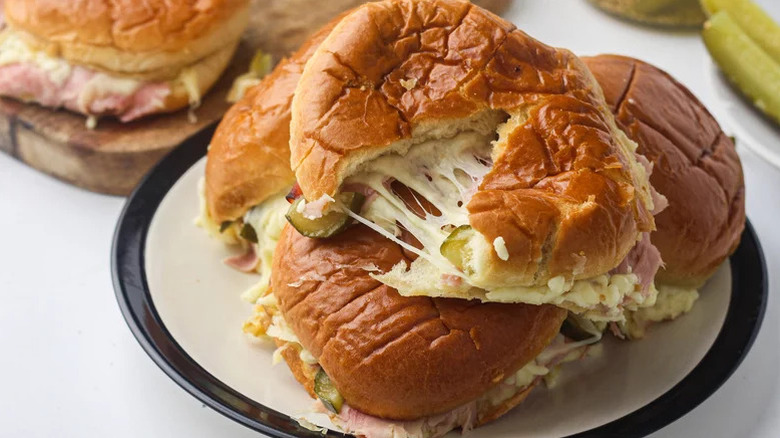 Plate of ham and cheese sliders with pickles