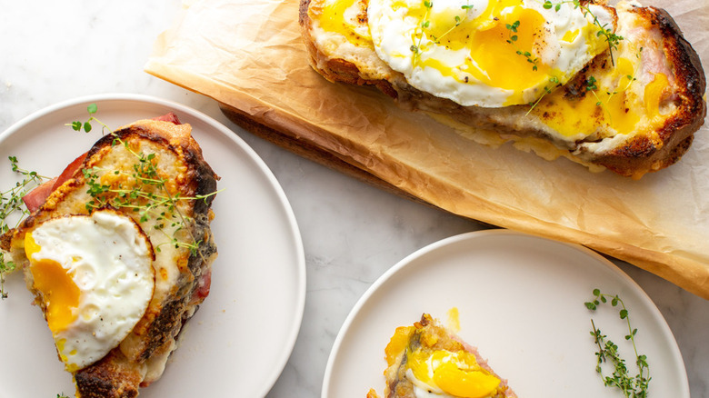 Croque madames on plates and a cutting board