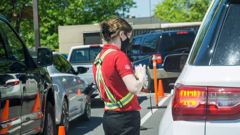 A Chick-fil-A employee taking a drive-thru order