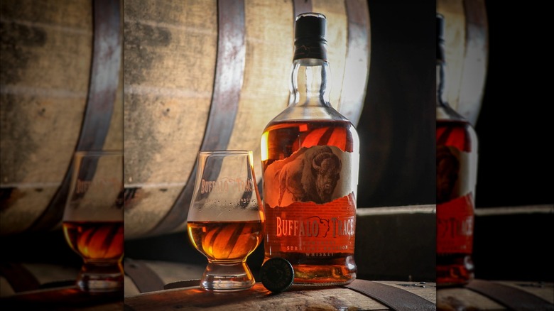 Bottle and glass of Buffalo Trace on barrels
