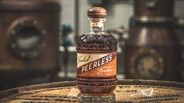 Bottle of Peerless Toasted Bourbon sitting on barrel