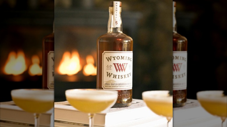 Bottle of Wyoming Whiskey on book with two cocktails