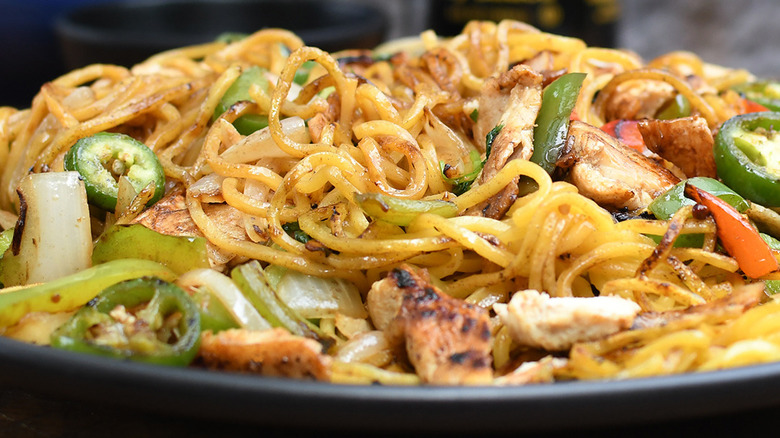 Close-up of a bowl of HuHot Mongolian barbeque with meat, veggies, and noodles