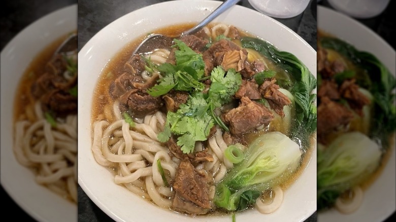 A bowl of beef noodle soup with leeks and fresh cilantro at Chin's Kitchen