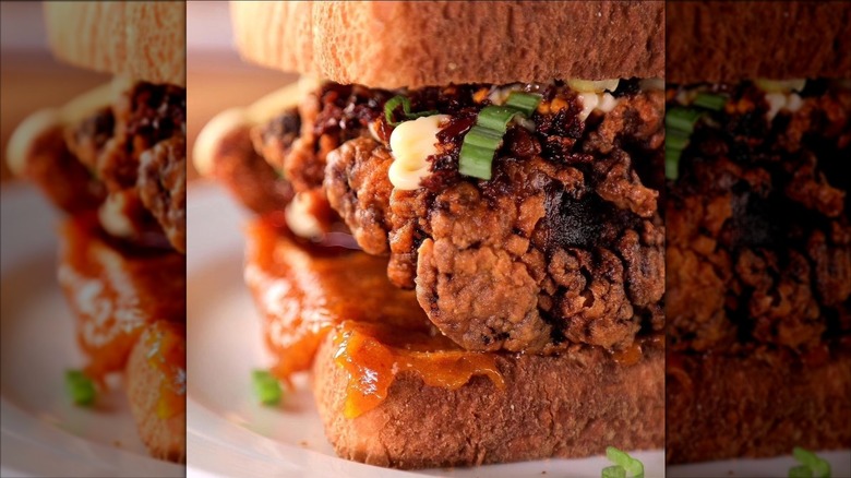 Close up of Sichuan pepper jelly chicken sandwich from Loaf restaurant with fried chicken, chili crisp, and green onion